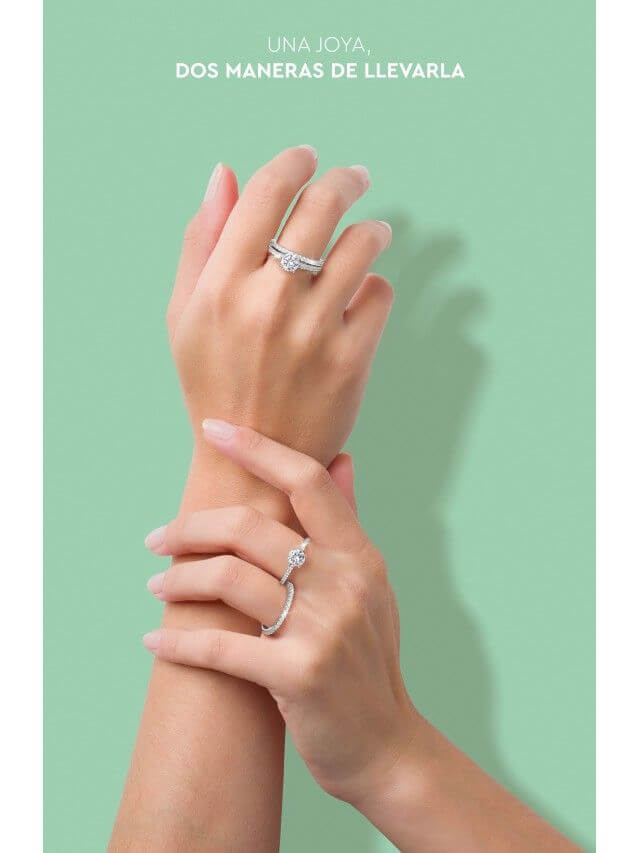 Manos femeninas con anillos de plata de ley de la colección Mood de UNIKE. Diseño elegante y versátil, que permite dos opciones de uso, presentado sobre un fondo verde suave.